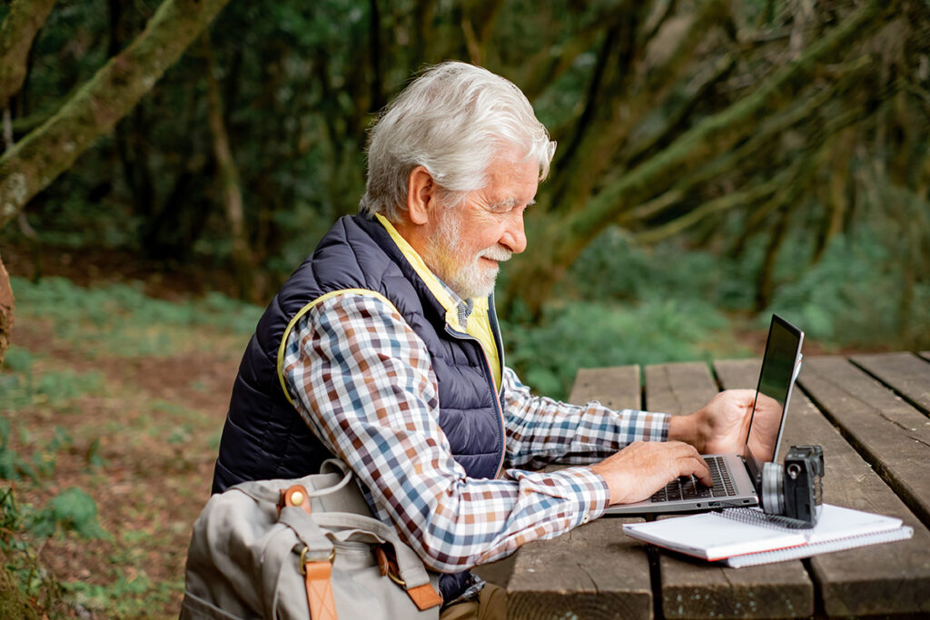 Family business owner working outdoors on his laptop